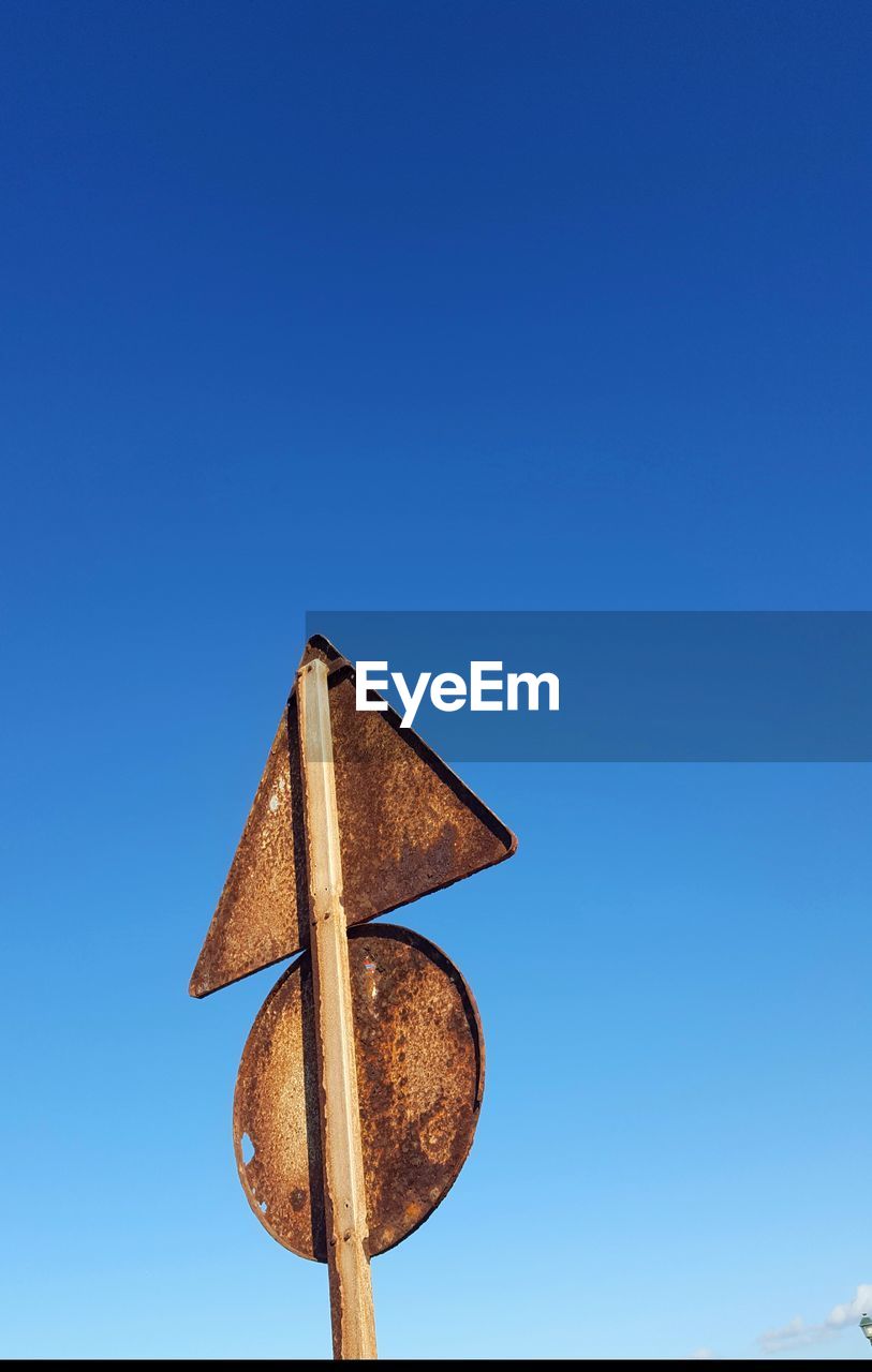 CLOSE-UP OF ROAD SIGN AGAINST CLEAR BLUE SKY