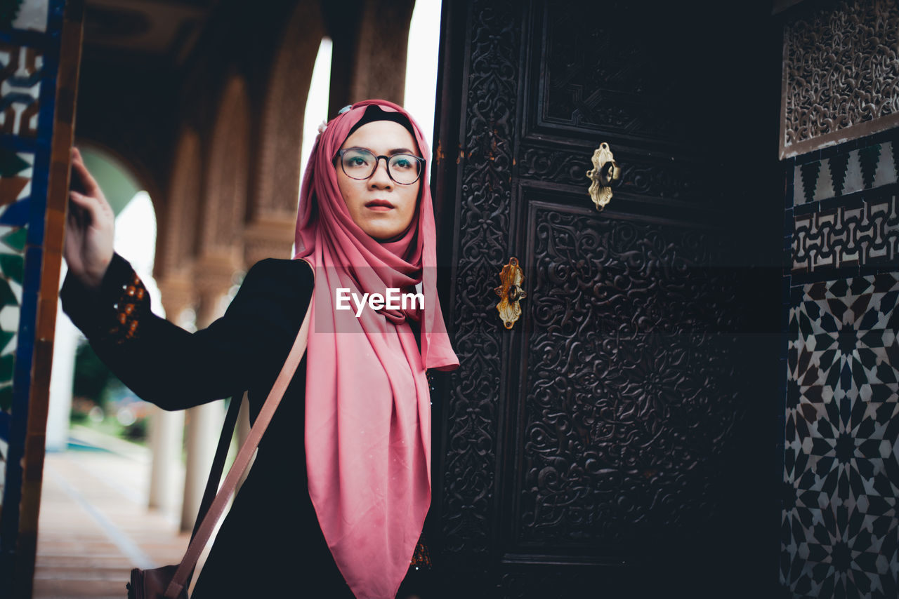 Woman standing at entrance of historic building