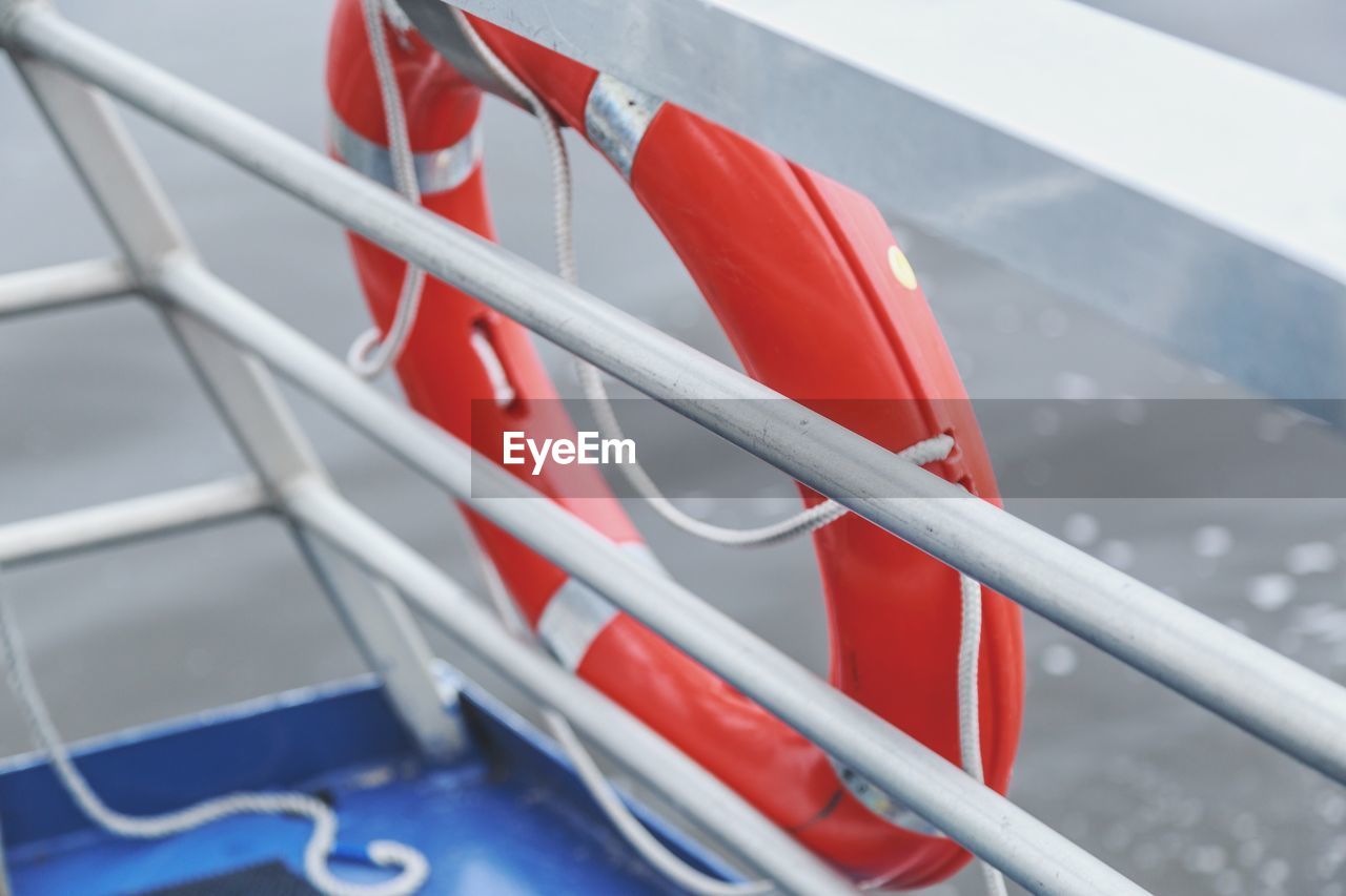 High angle view of lifebelt hanging on boat railing
