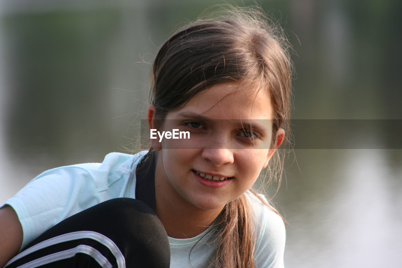 Portrait of smiling girl against lake