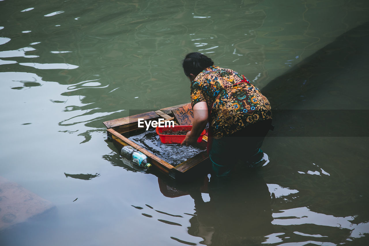 High angle view of woman fishing in lake