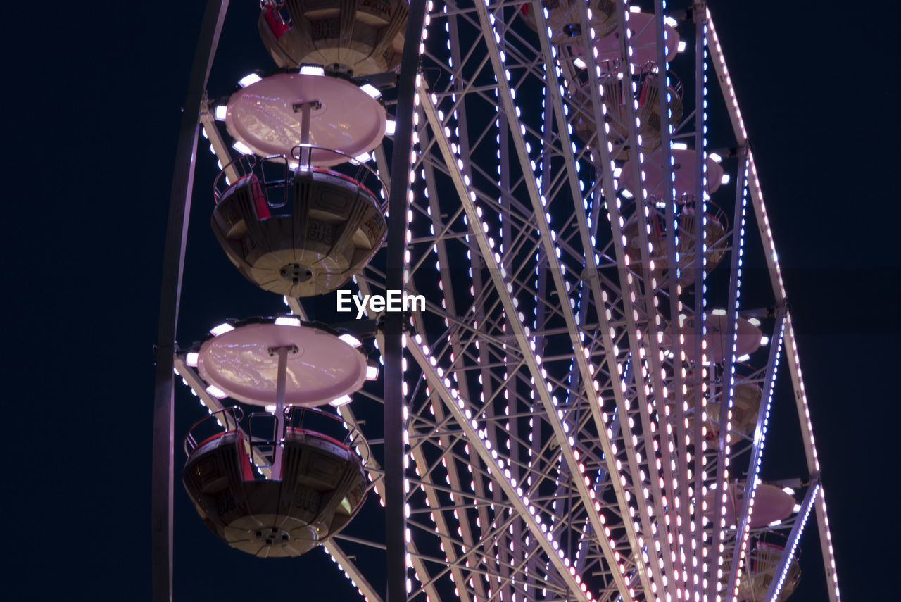 Low angle view of illuminated ferris wheel at night