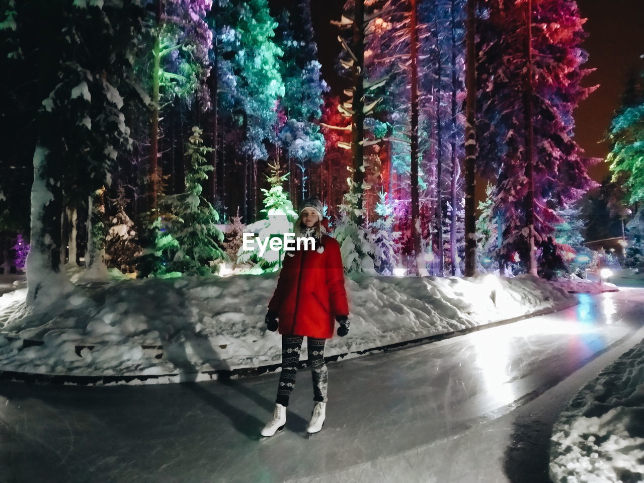 Full length of woman standing in park during winter at night