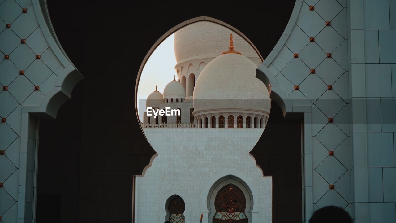 Historic mosque seen through arch during sunset