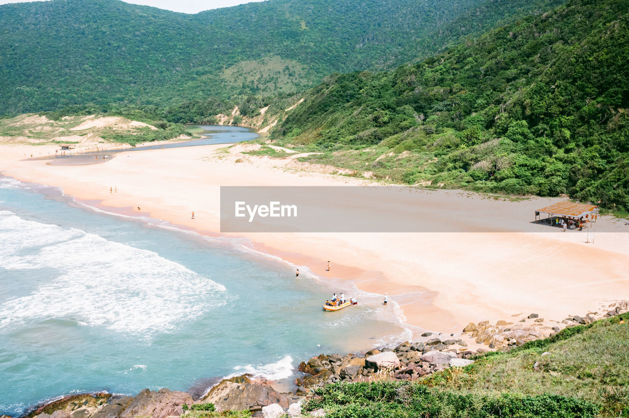 HIGH ANGLE VIEW OF BEACH BY MOUNTAINS