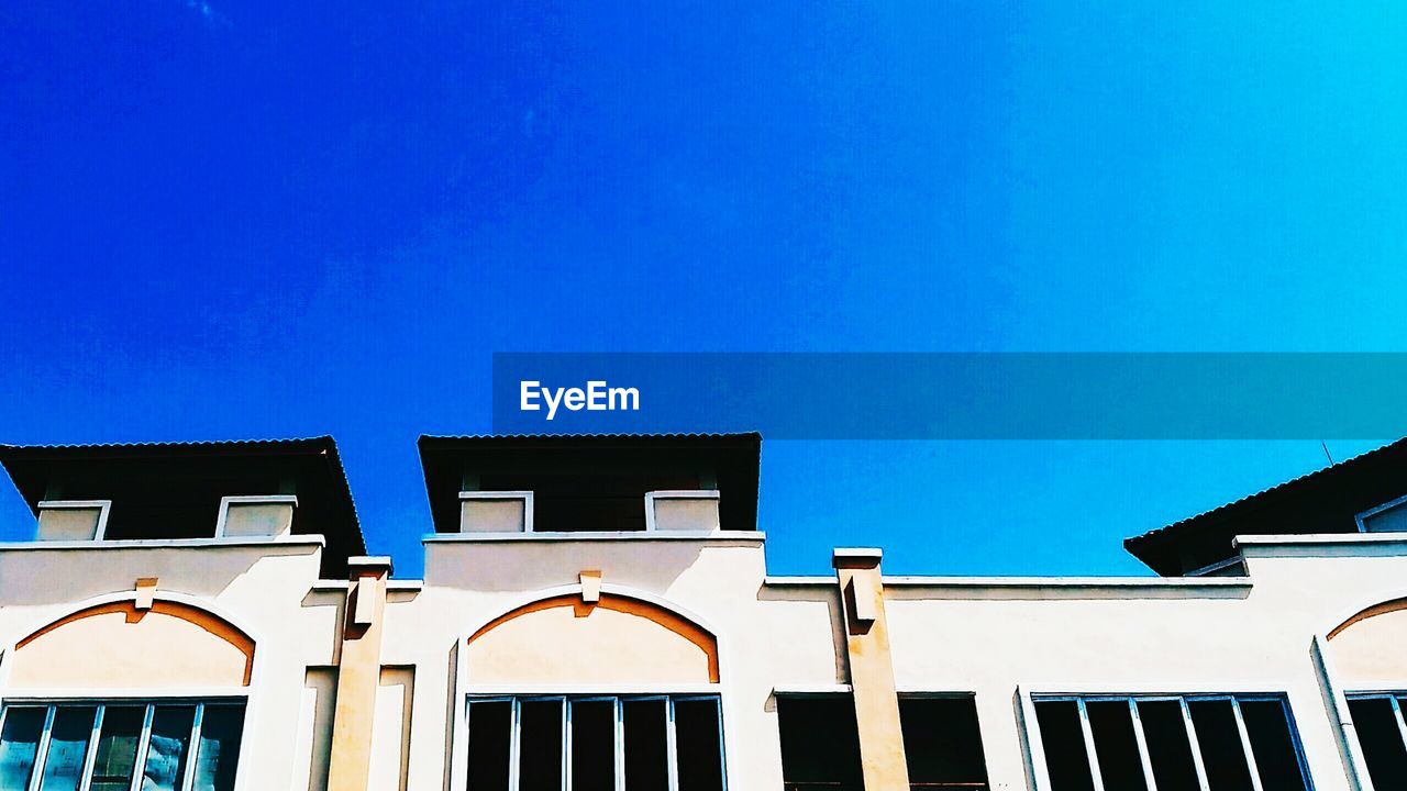 LOW ANGLE VIEW OF RESIDENTIAL BUILDING AGAINST BLUE SKY