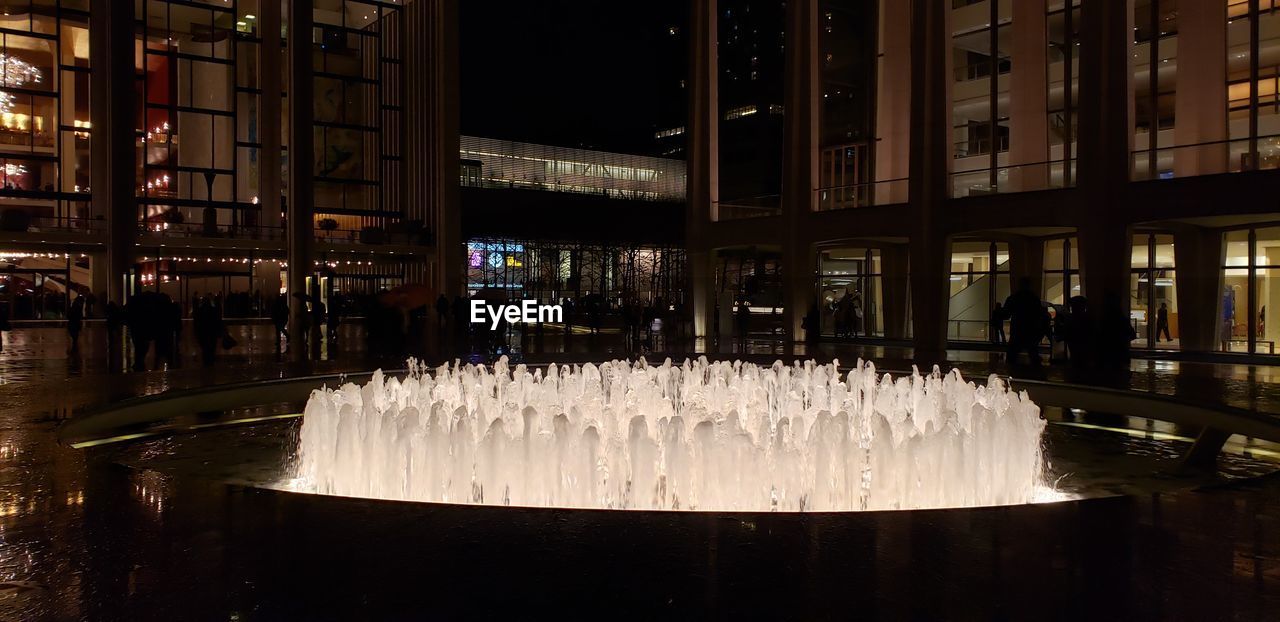 FOUNTAIN IN CITY AT NIGHT