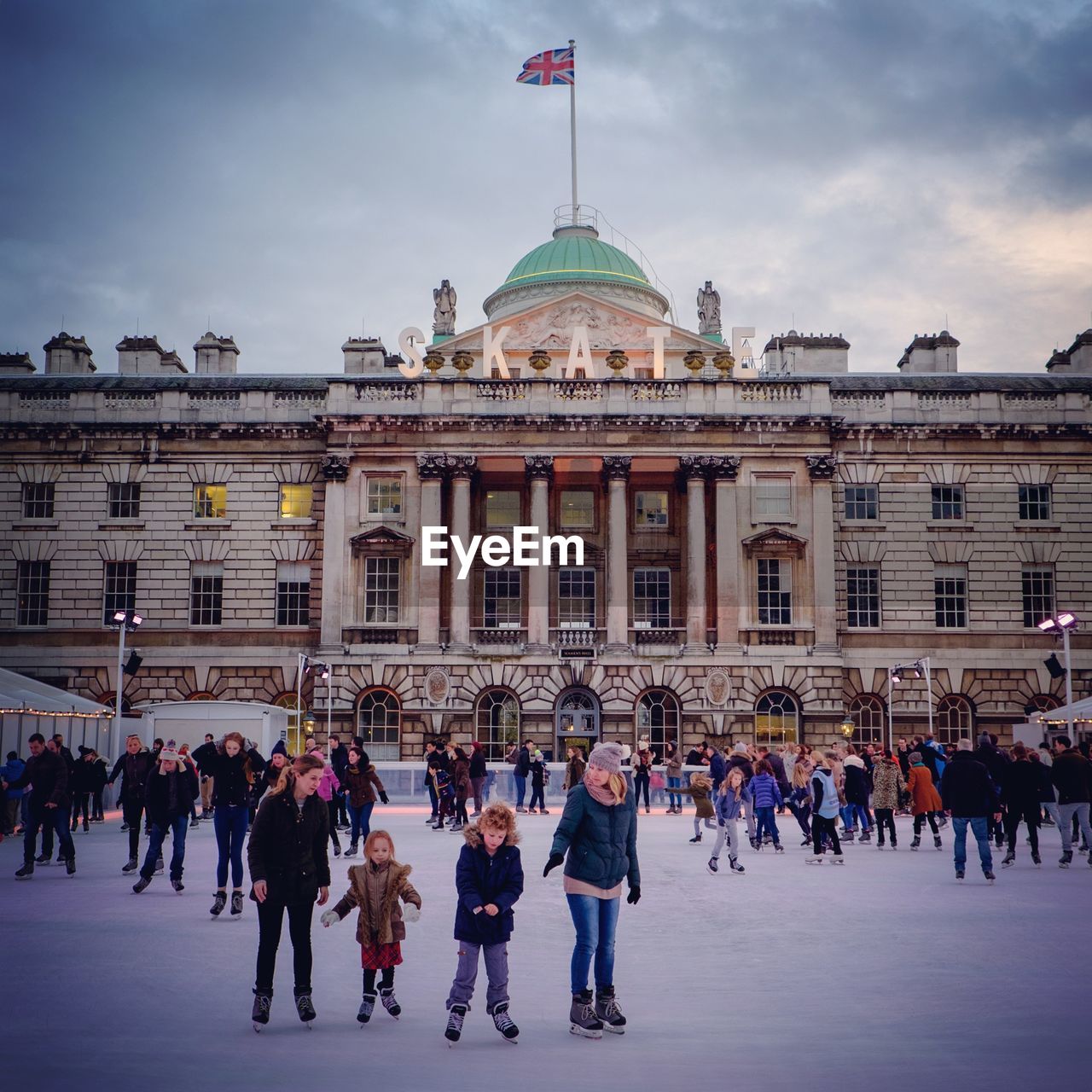 Crowd on ice rink against somerset house in city