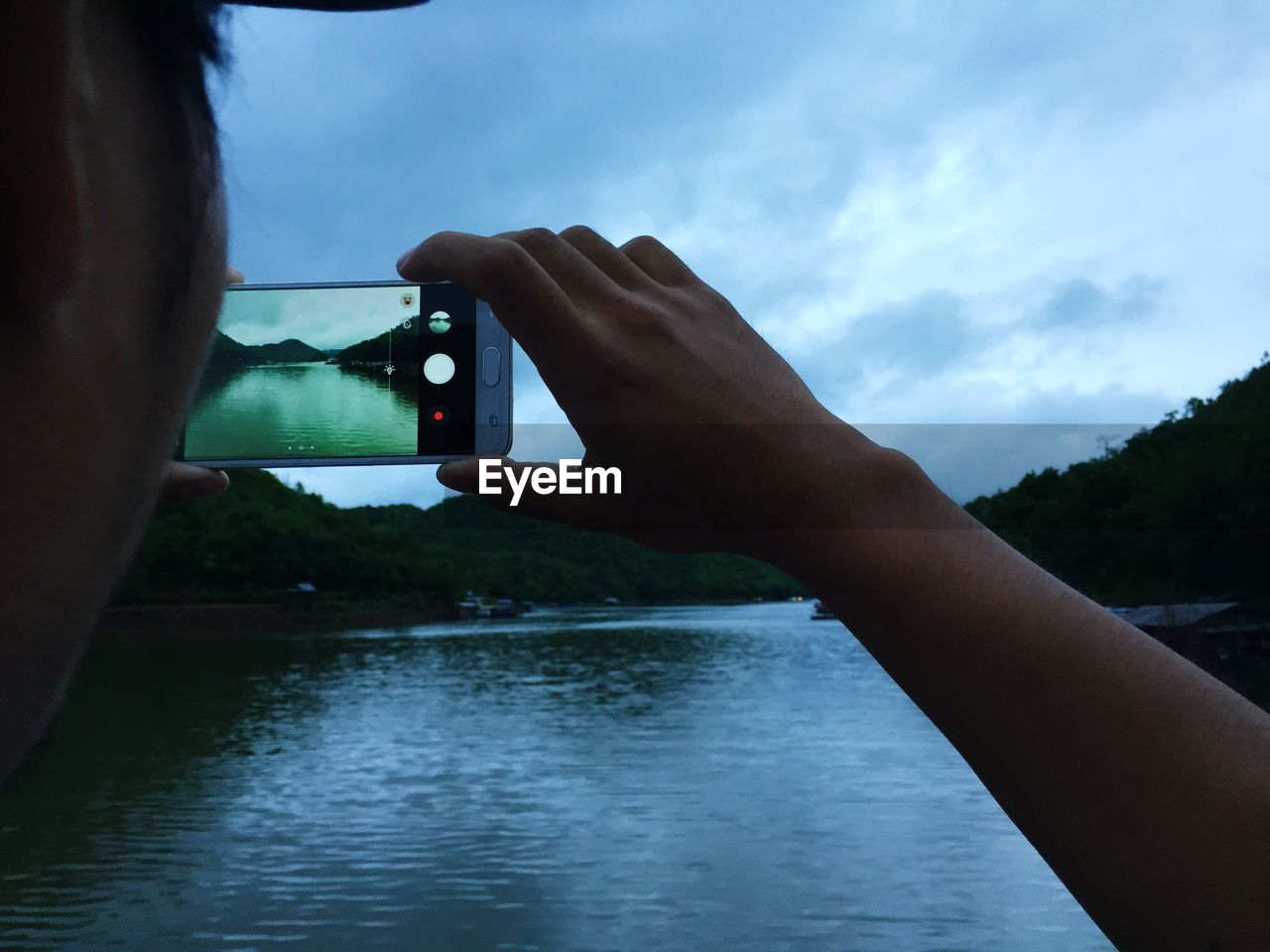 MIDSECTION OF MAN PHOTOGRAPHING AT CAMERA