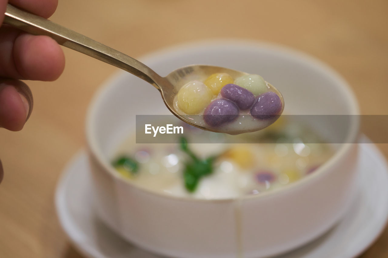 CLOSE-UP OF PERSON HAND HOLDING BOWL OF EGGS