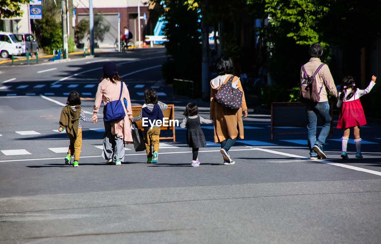 GROUP OF PEOPLE WALKING ON ROAD