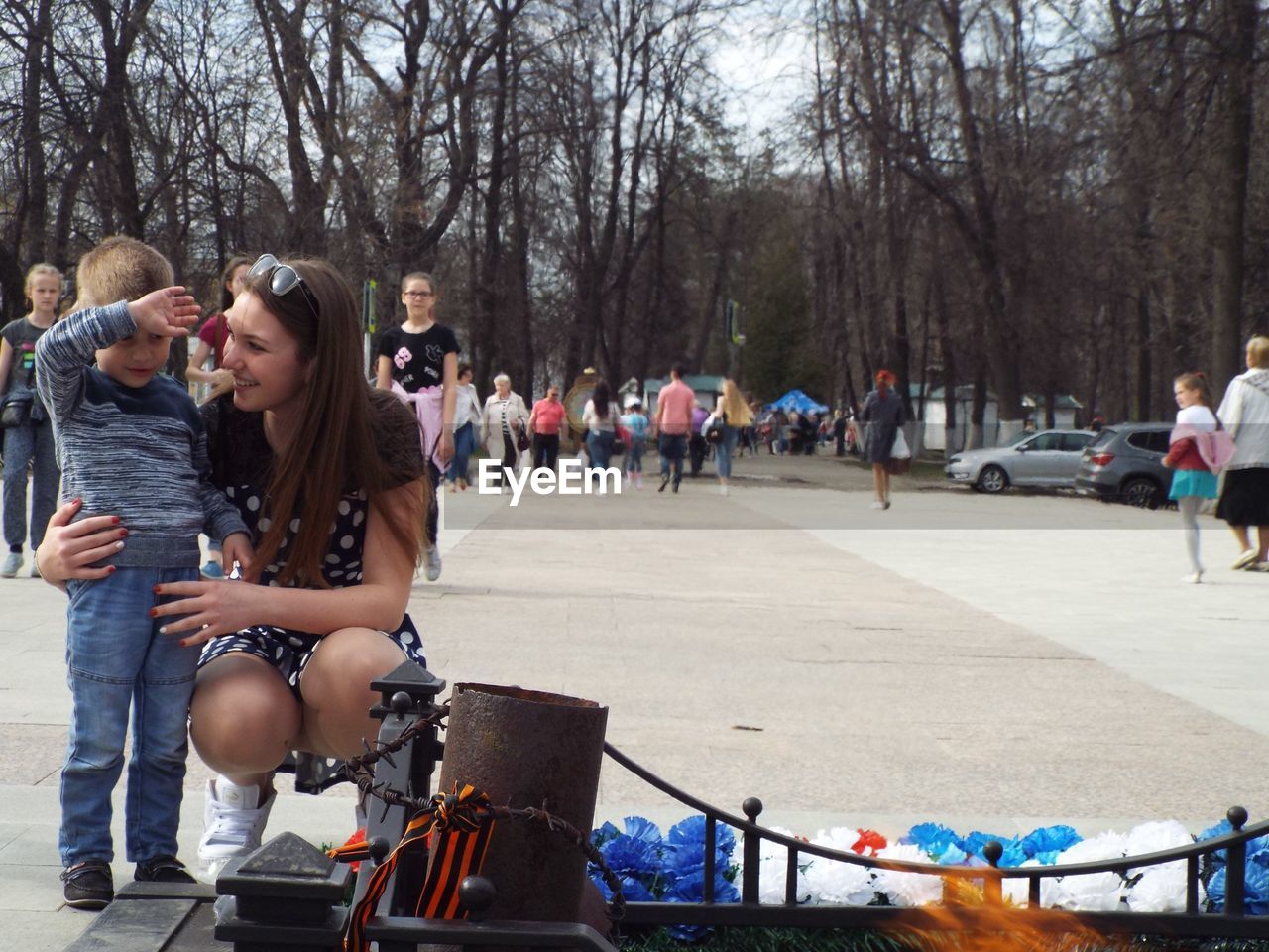 Mother crouching by son on walkway