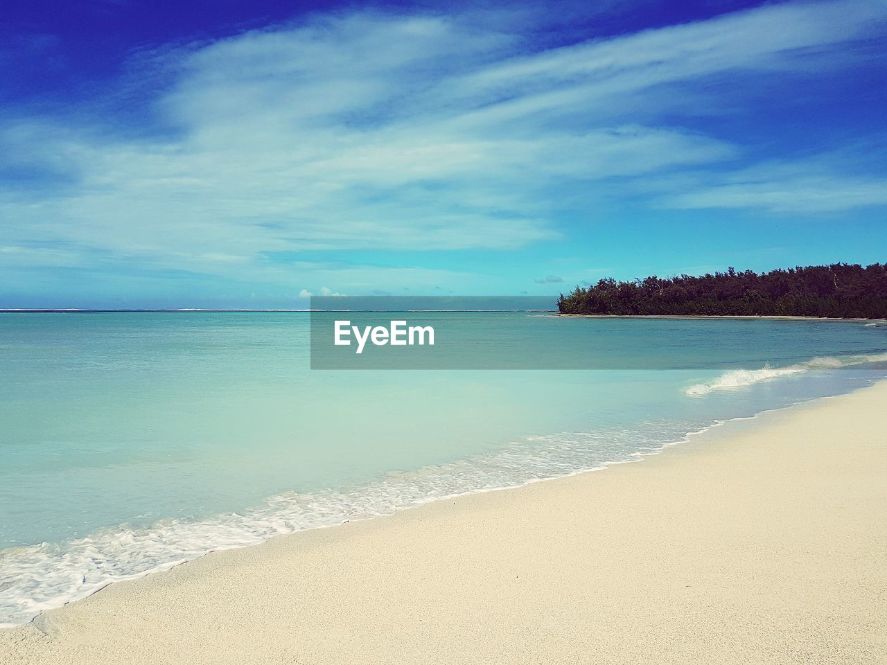 Scenic view of beach against blue sky