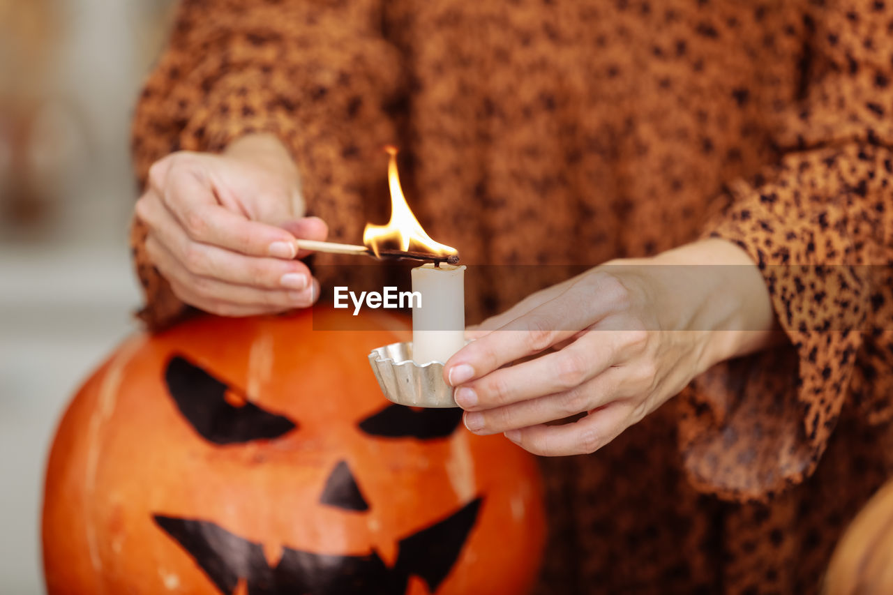 midsection of man holding jack o lantern