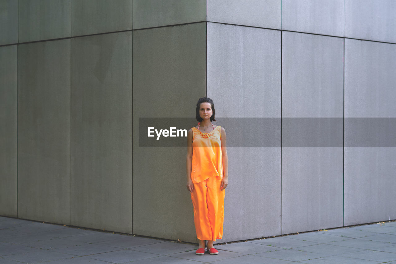 Woman standing on the corner of the building to make the view of symmetry