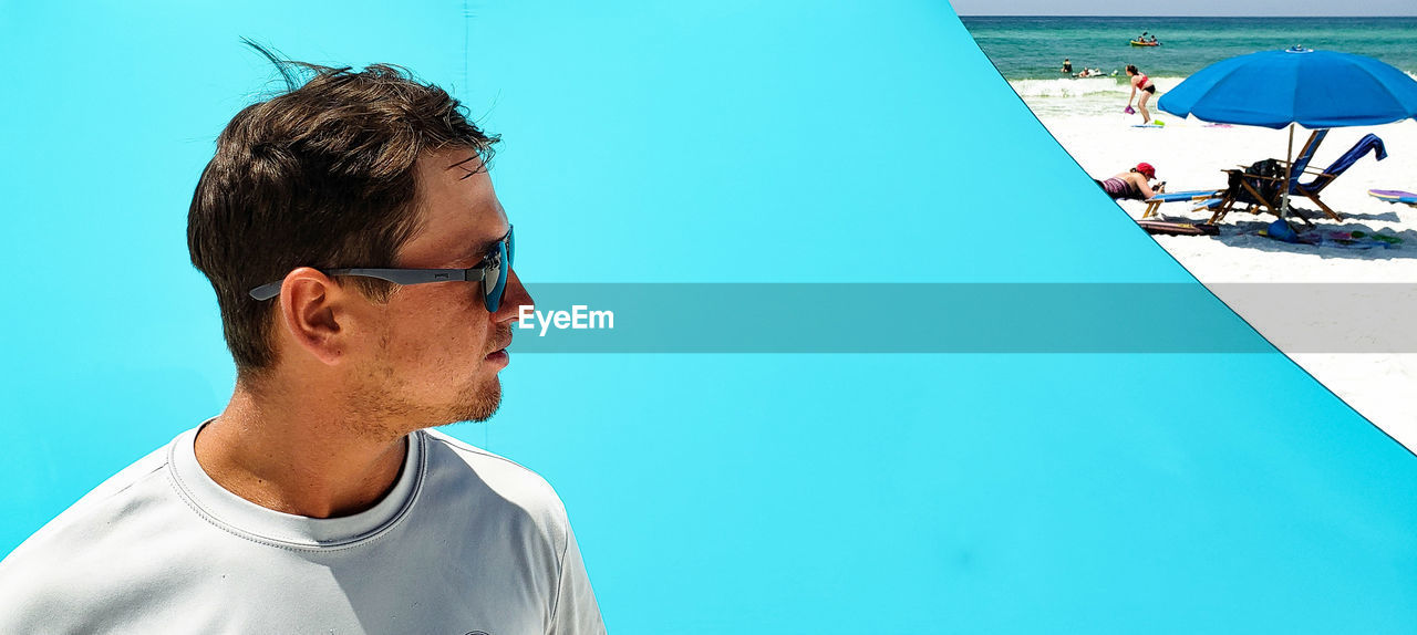 PORTRAIT OF YOUNG MAN BY SWIMMING POOL