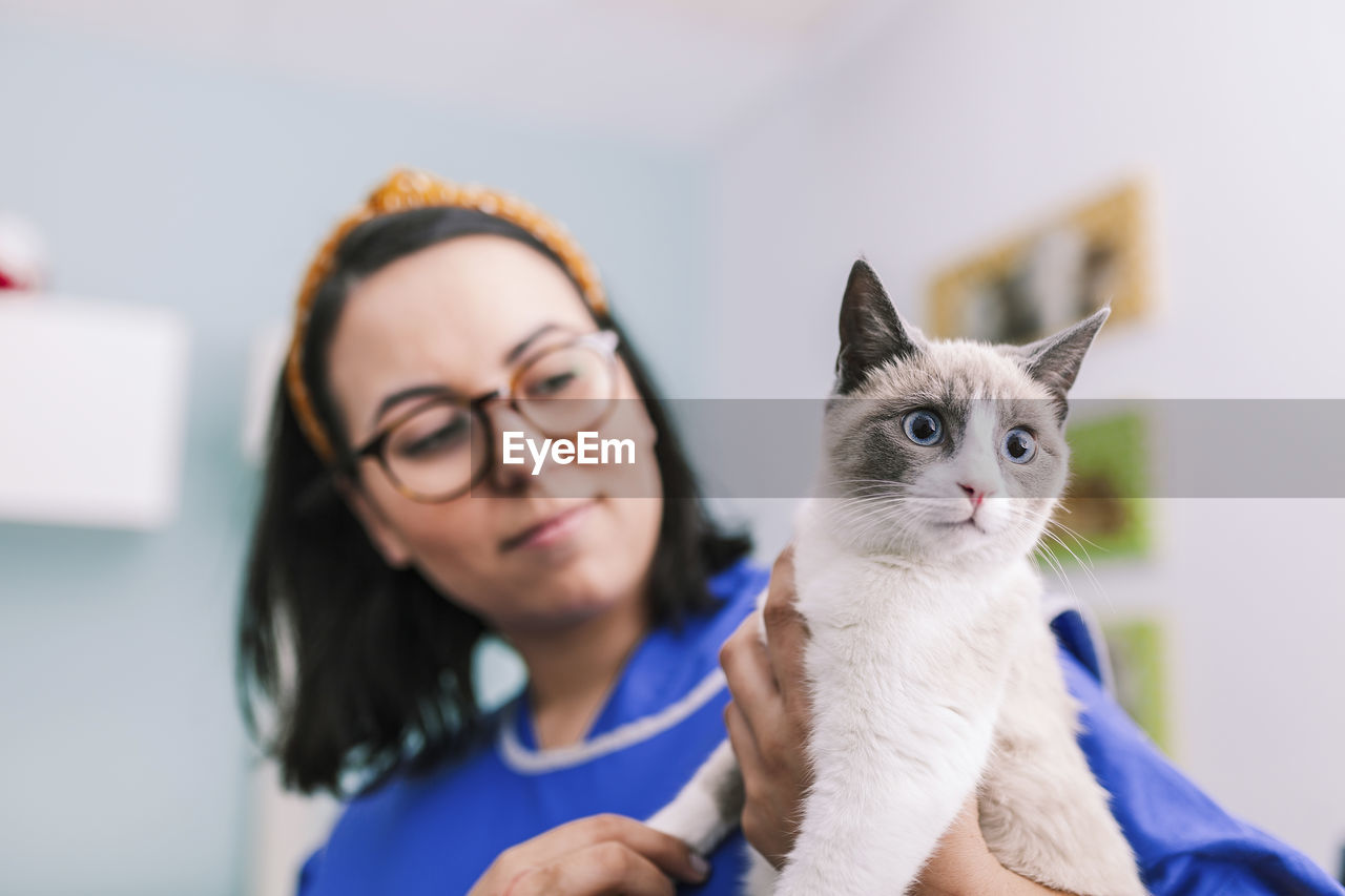 Woman holding cat at animal hospital