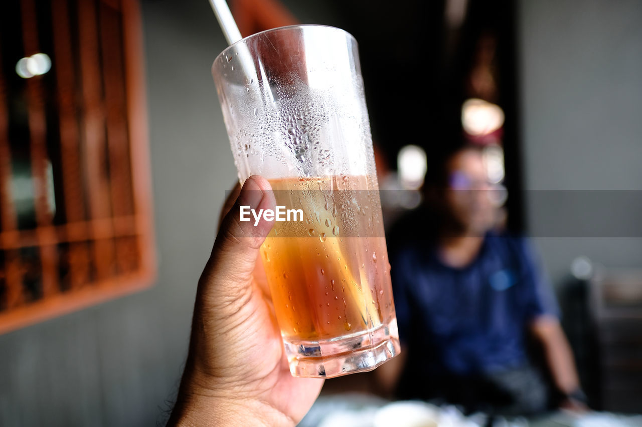 Cropped hand holding drink in glass