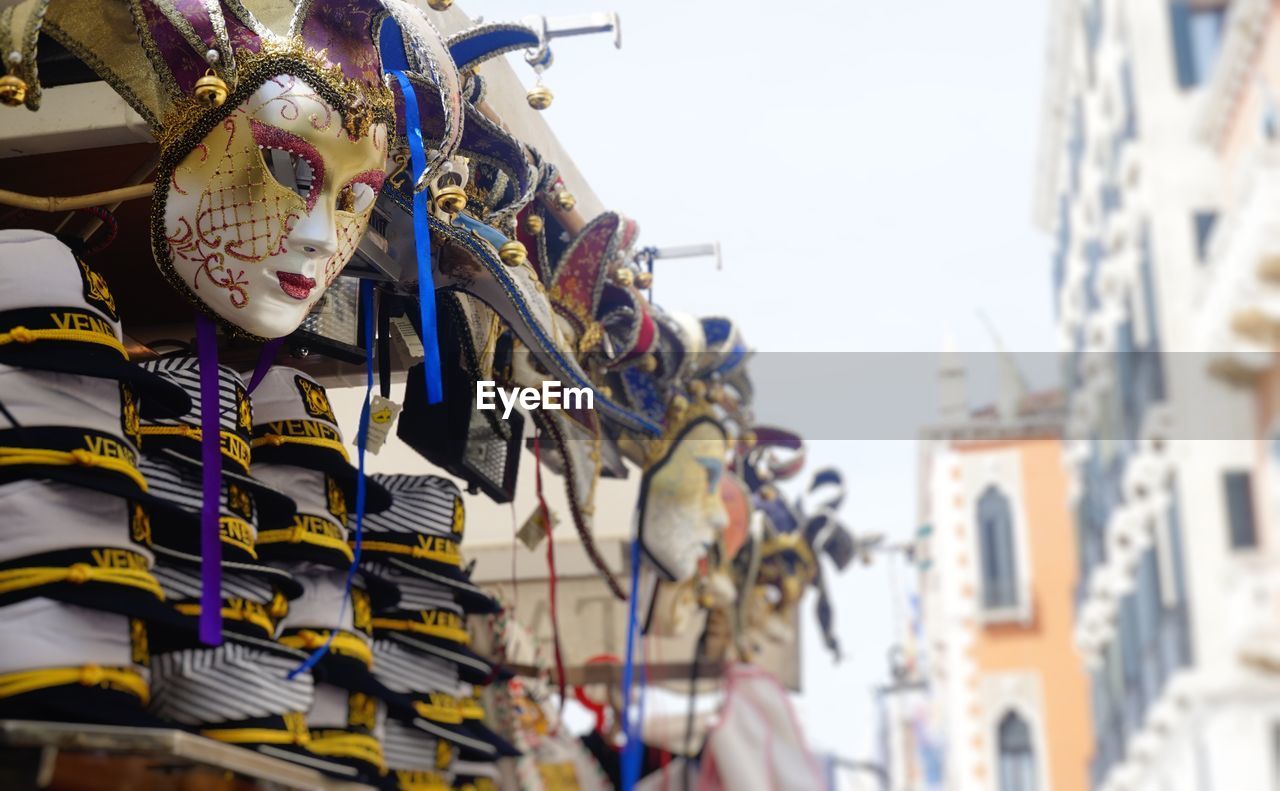 Low angle view of masks and headwear at market stall