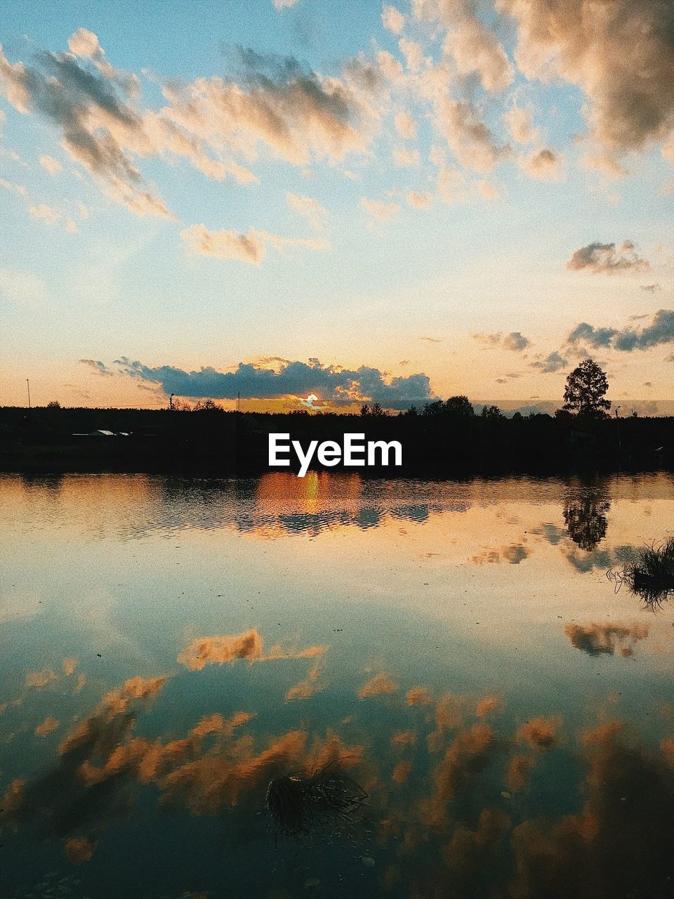 Scenic view of lake against sky at sunset