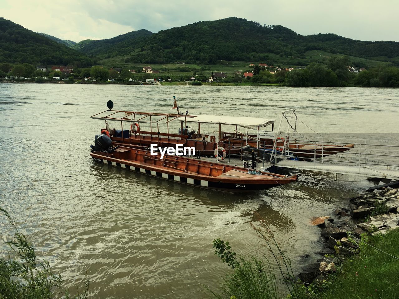 Boat moored on river against sky