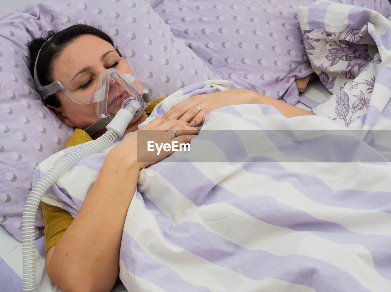 Woman wearing oxygen while sleeping on bed in hospital