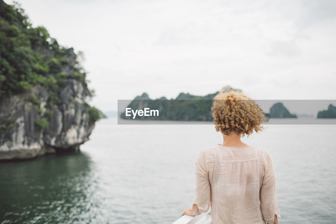 Rear view of woman looking at sea against sky