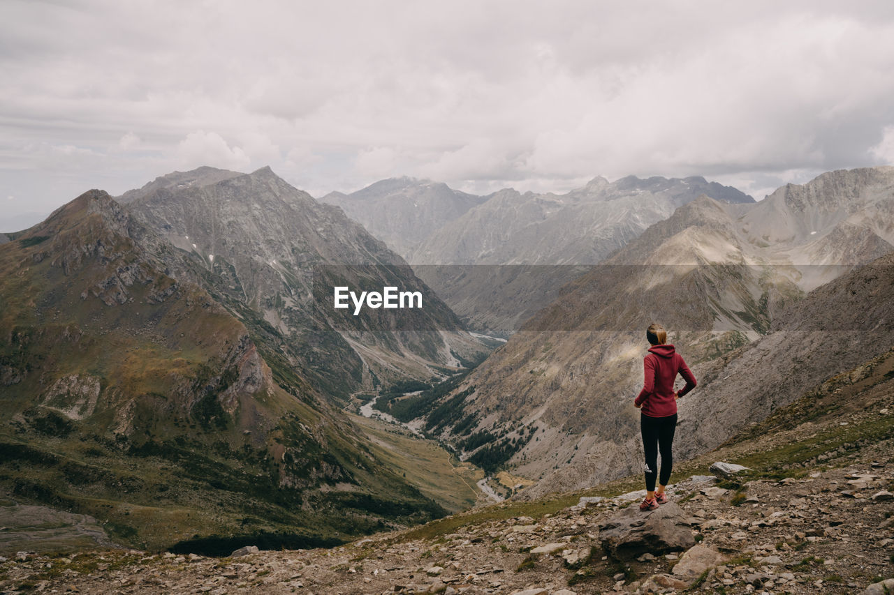 REAR VIEW OF MAN LOOKING AT MOUNTAINS