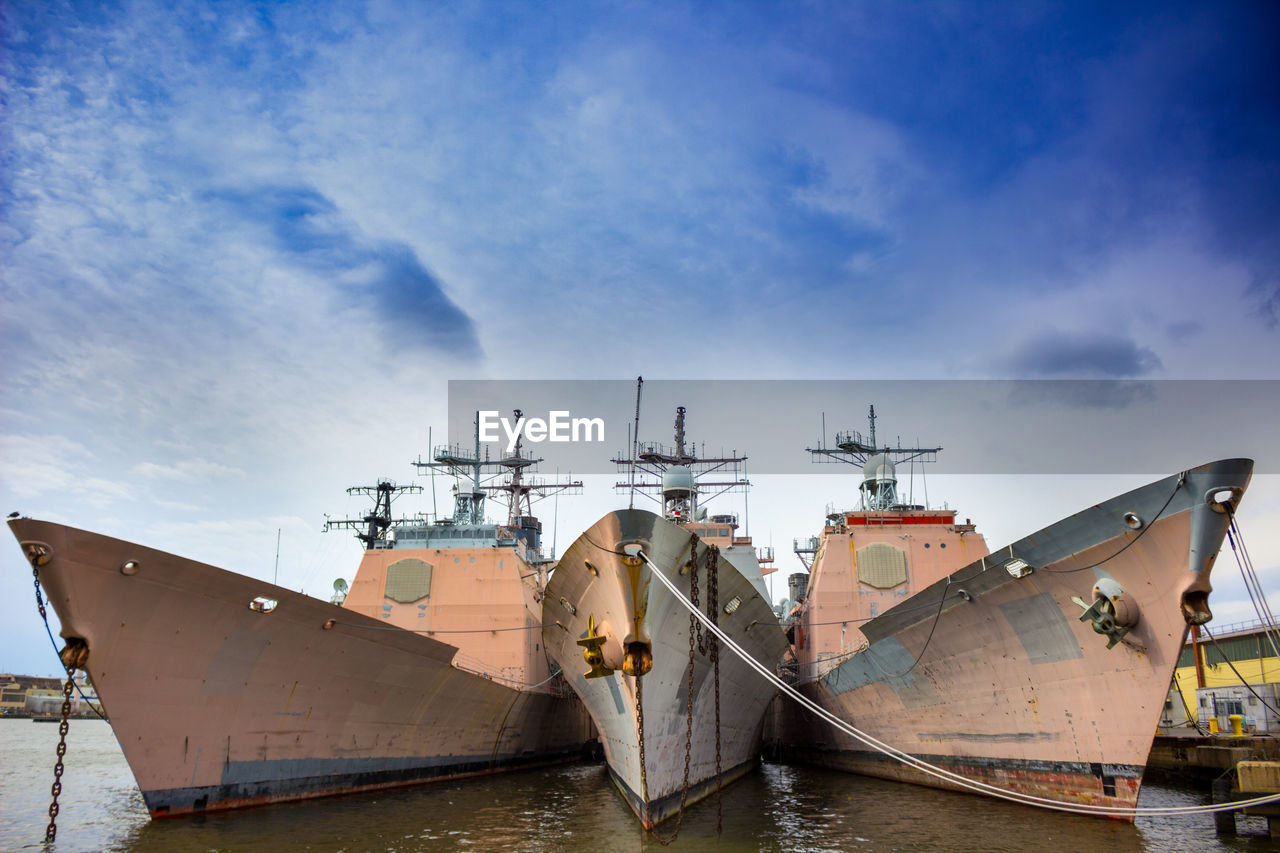 Ship moored at harbor against sky