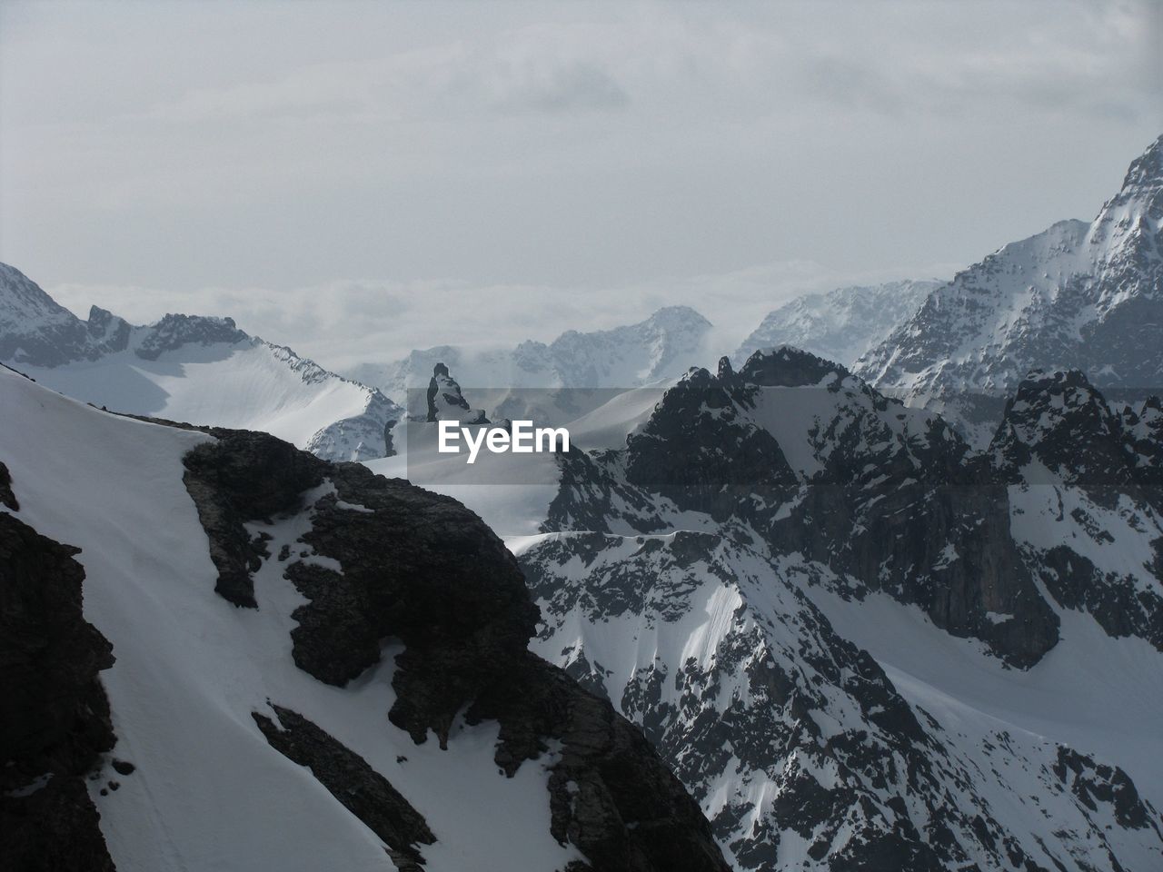 SNOW COVERED MOUNTAINS AGAINST SKY