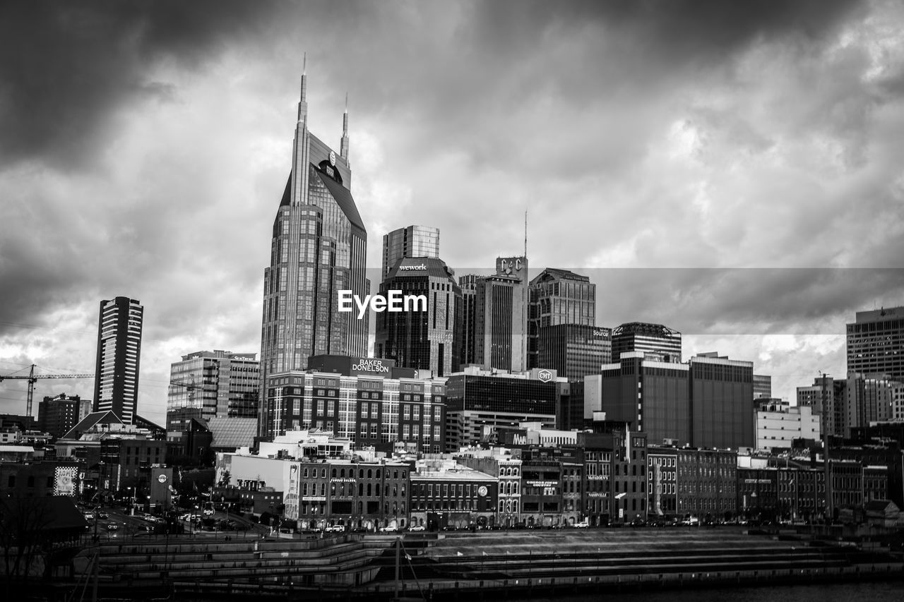 Skyscrapers in city against cloudy sky