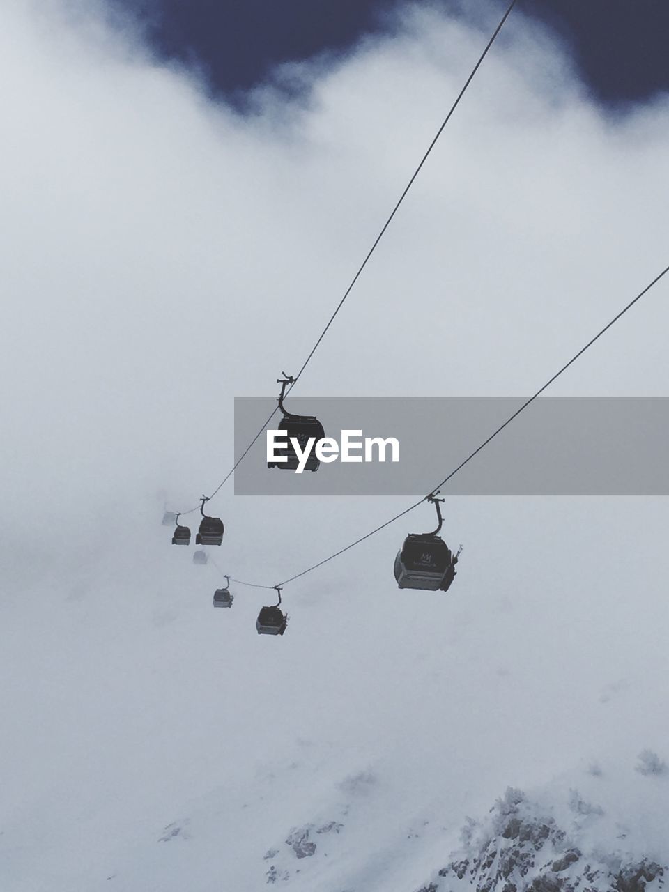 Ski lift at foggy snowcapped mountain