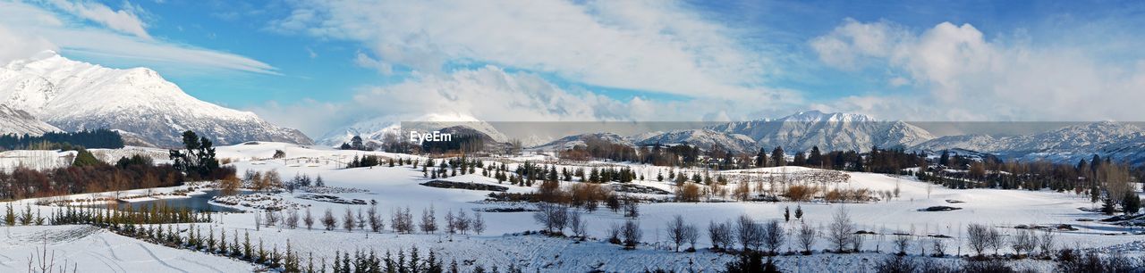 Panoramic view of snow-covered landscape against sky
