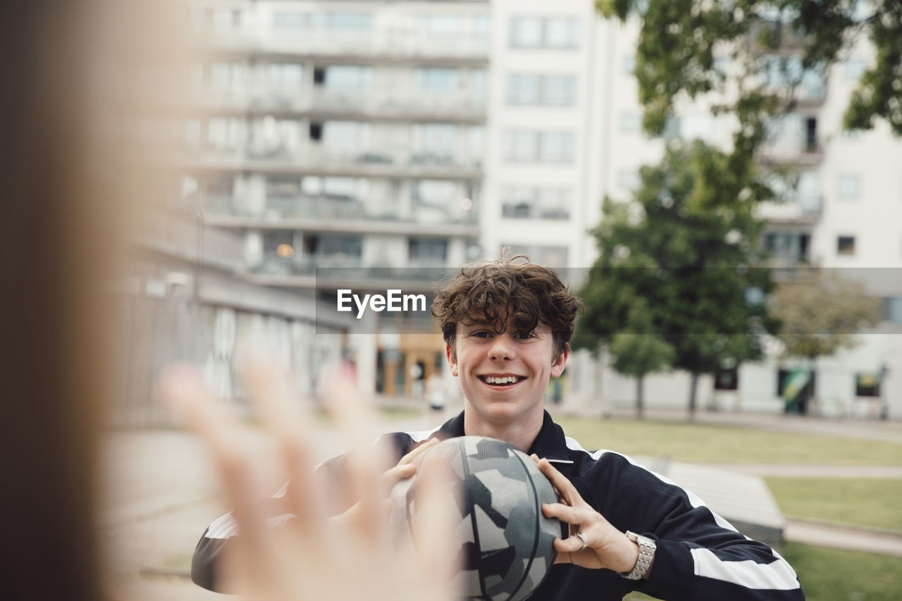 Smiling teenage boy playing with friend in park