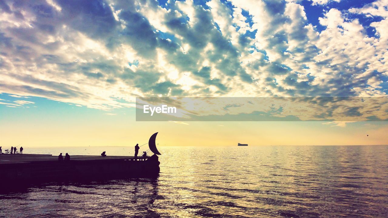 SILHOUETTE PEOPLE ON BOAT IN SEA AGAINST SKY