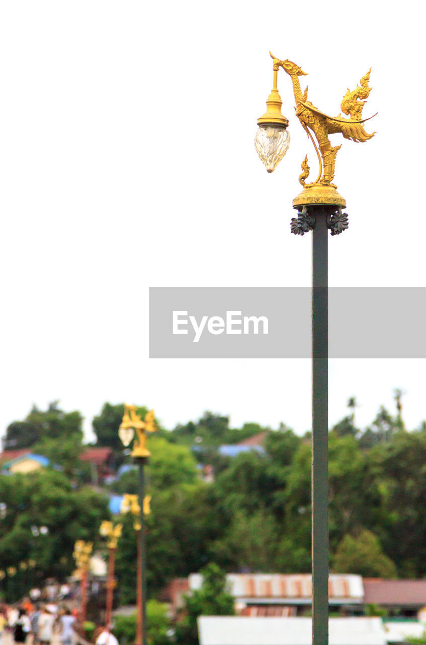 Low angle view of golden lamp post on bridge against clear sky