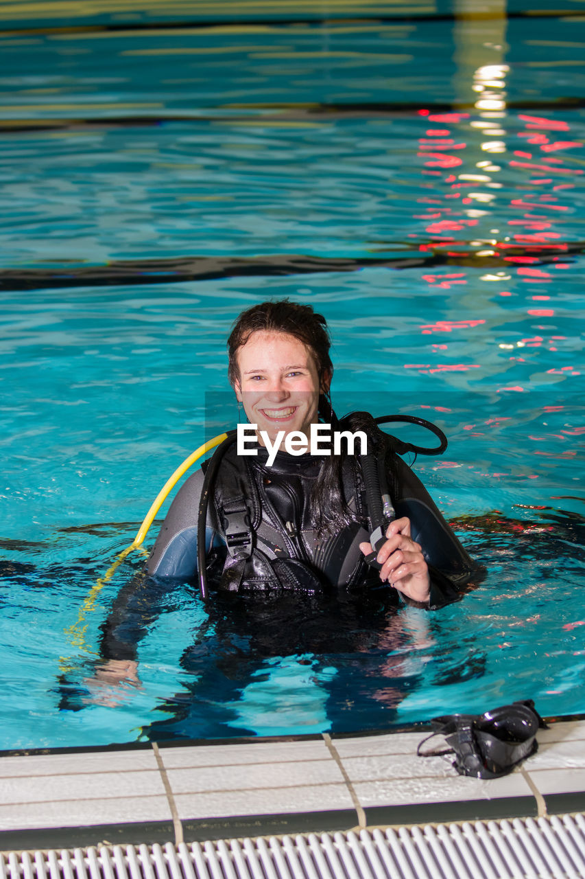 Portrait of smiling young woman in swimming pool