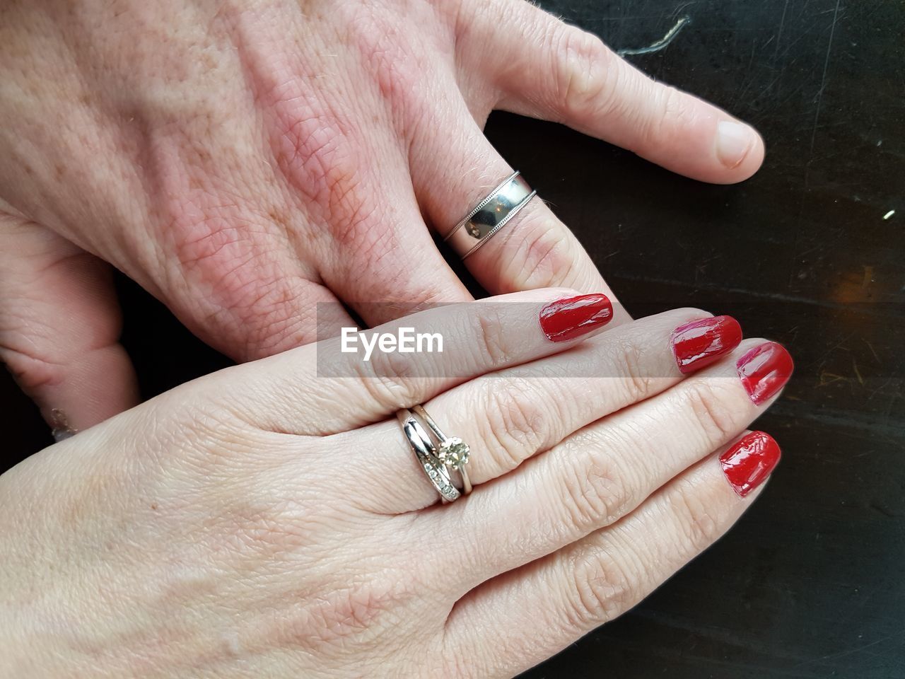 Cropped image of married couple with wedding ring on table