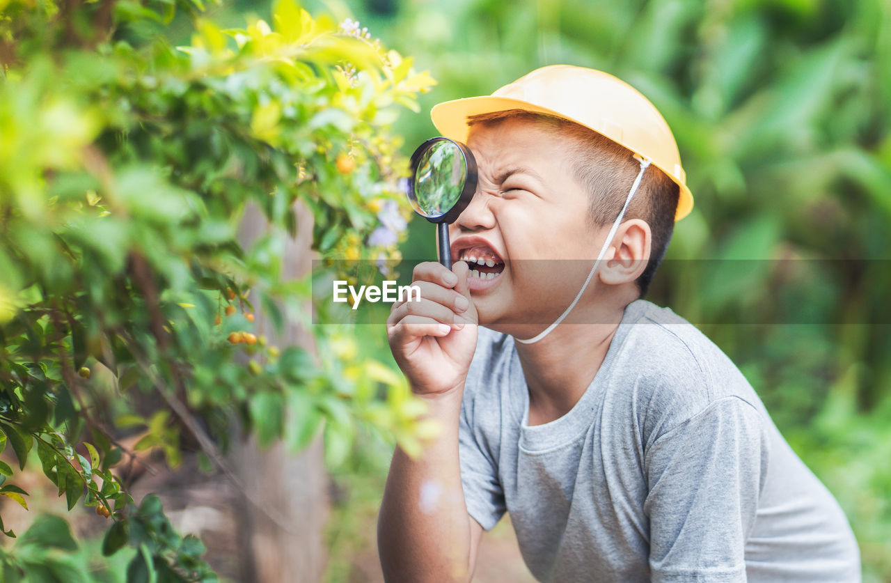 Close-up of boy looking through magnifying glass
