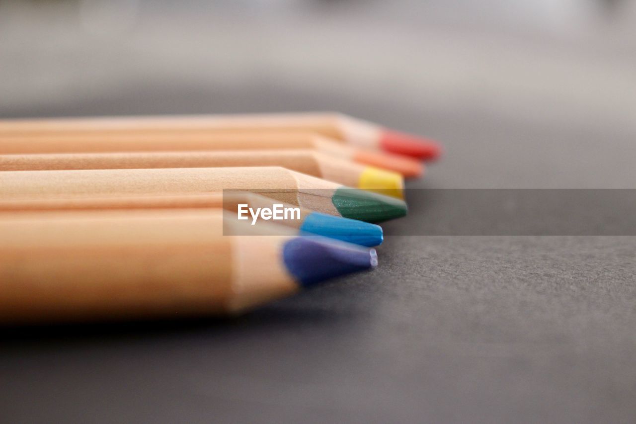 Surface level of wooden colored pencils on blackboard