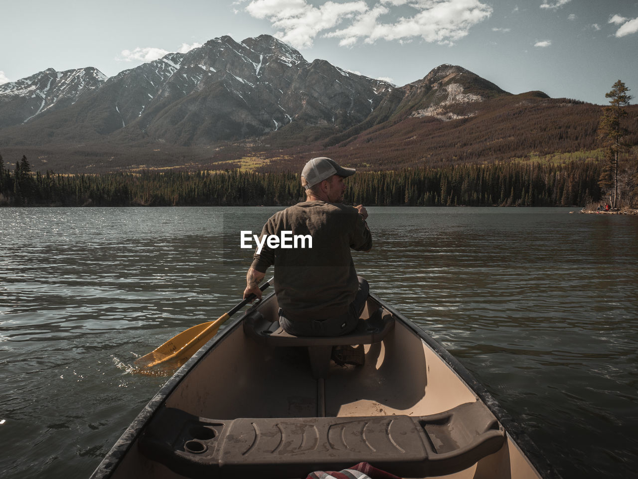 Rear view of man paddling boat in lake