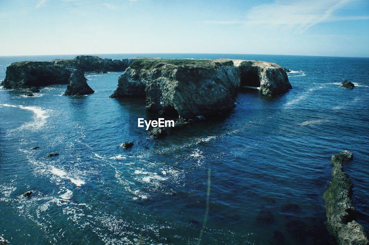 High angle view of rock formation amidst sea against sky