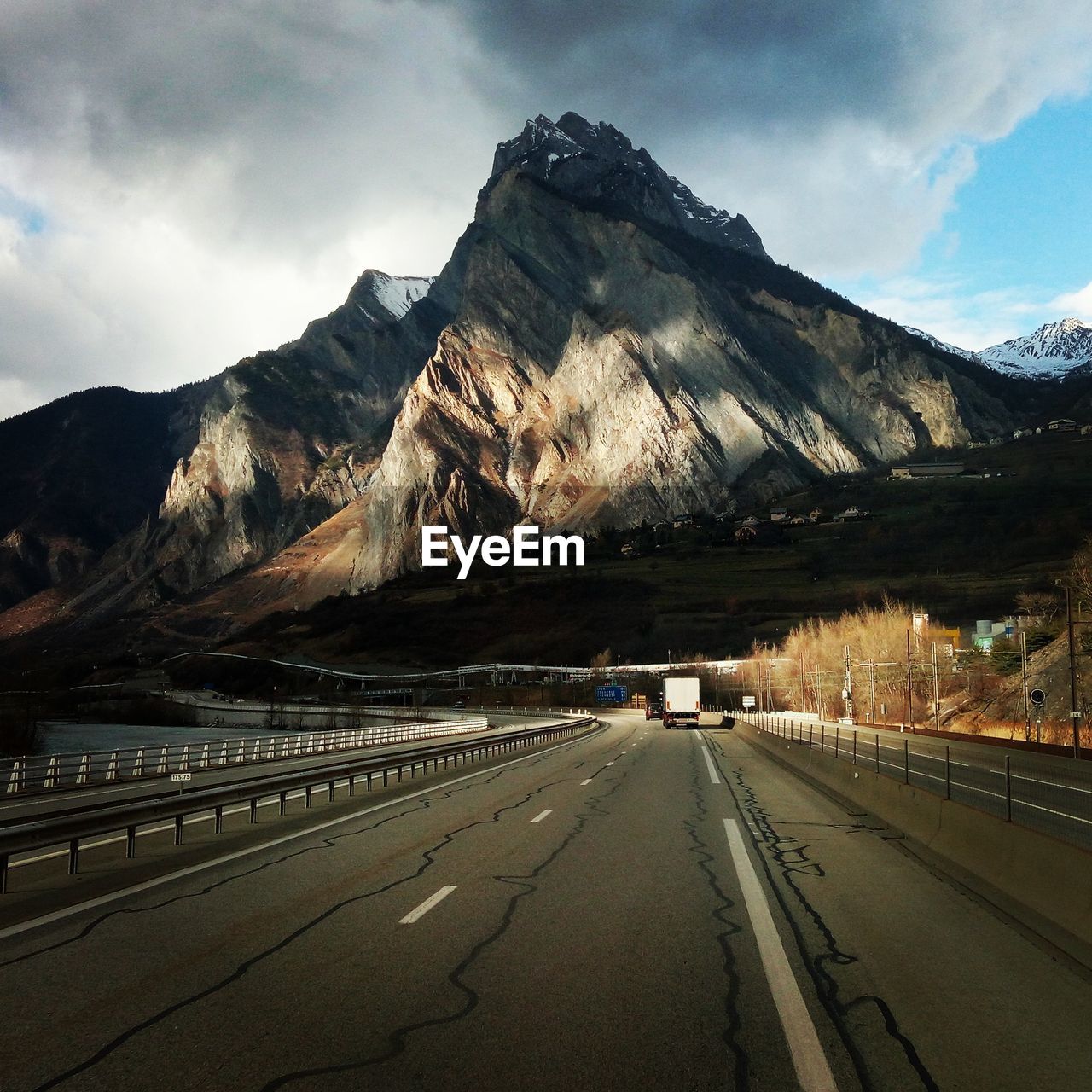 Road by mountains against sky