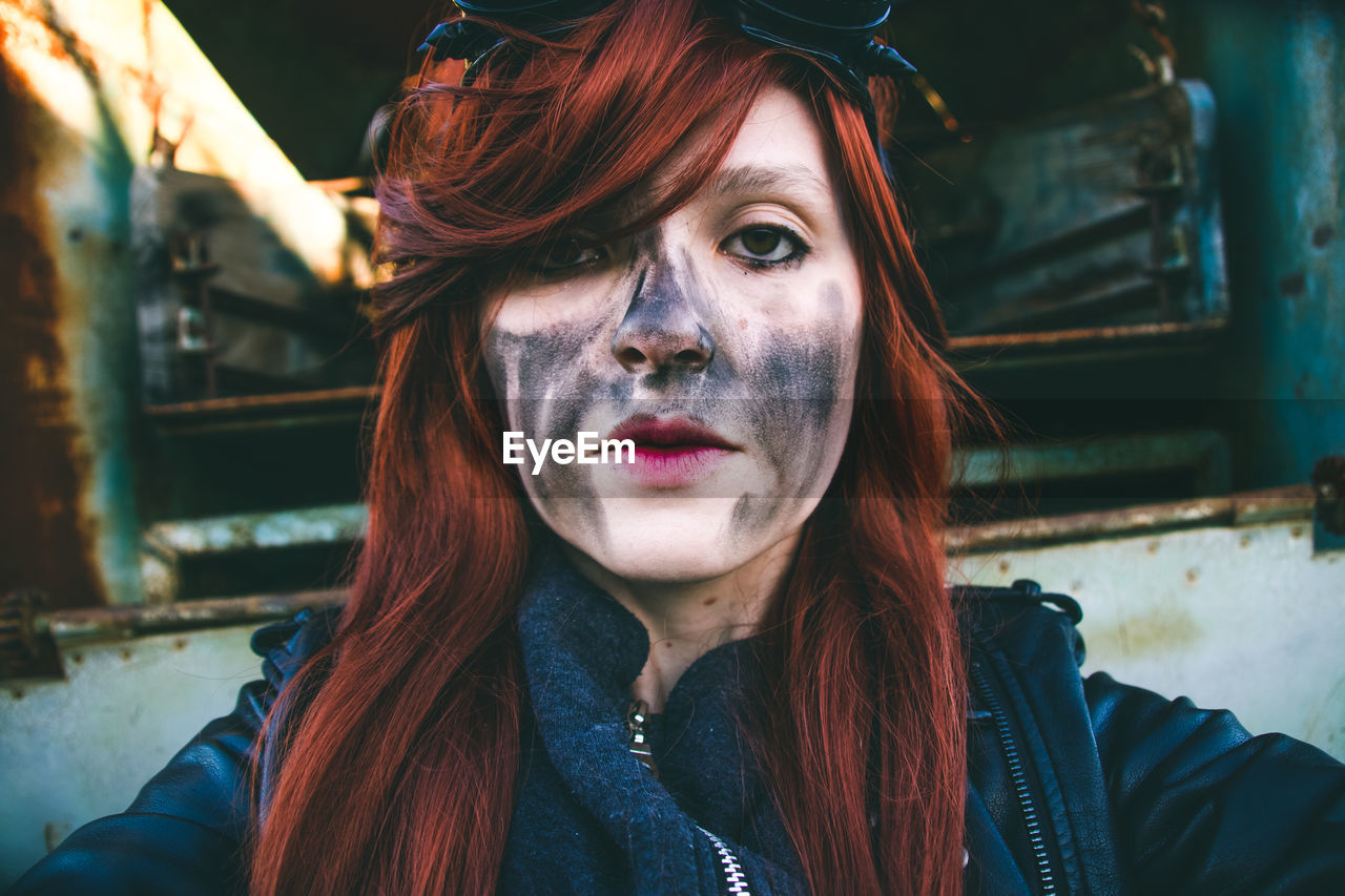 Portrait of young woman with charcoal stain on face