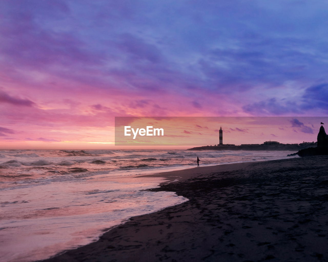 Scenic view of sea against dramatic sky during sunset