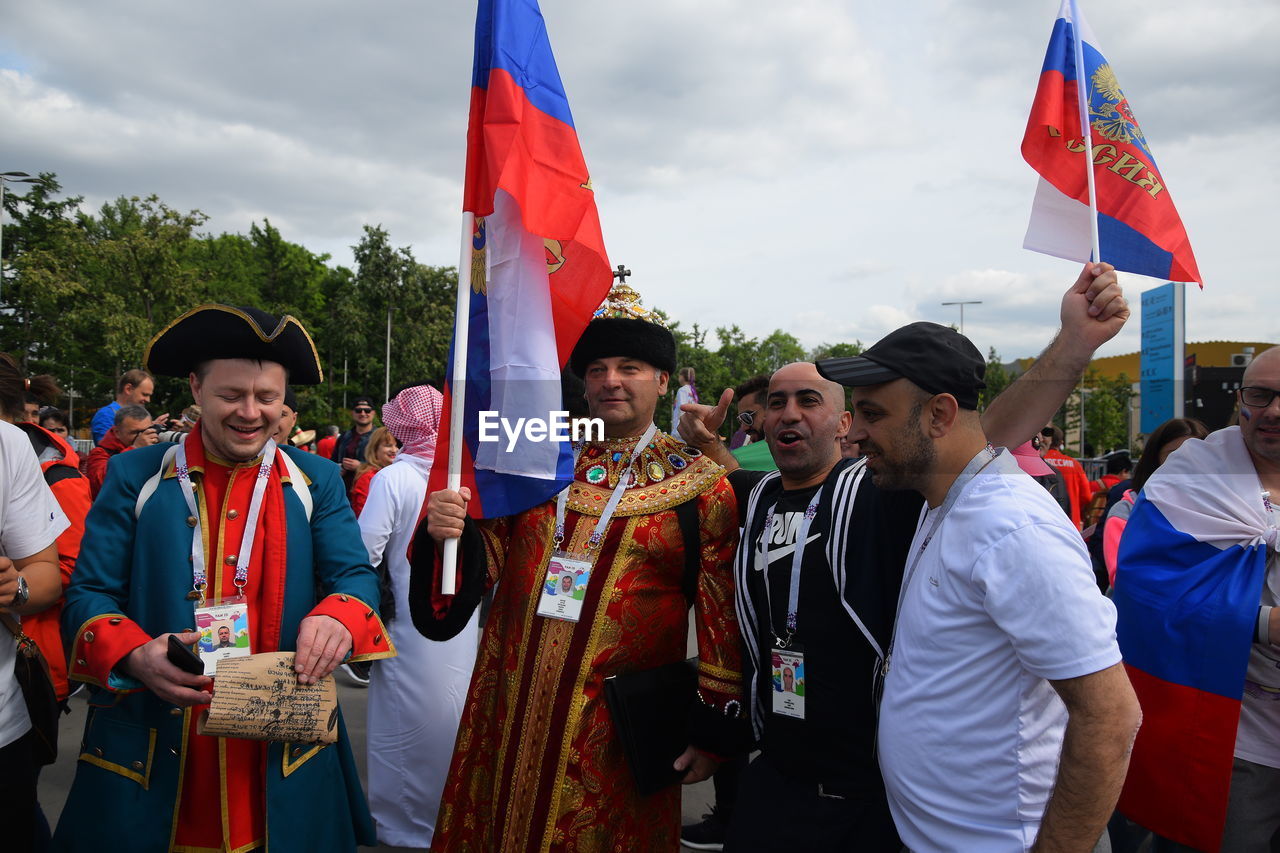 PANORAMIC VIEW OF PEOPLE STANDING BY FLAGS