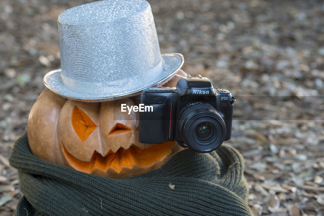 CLOSE-UP OF CAMERA PHOTOGRAPHING WITH HAT