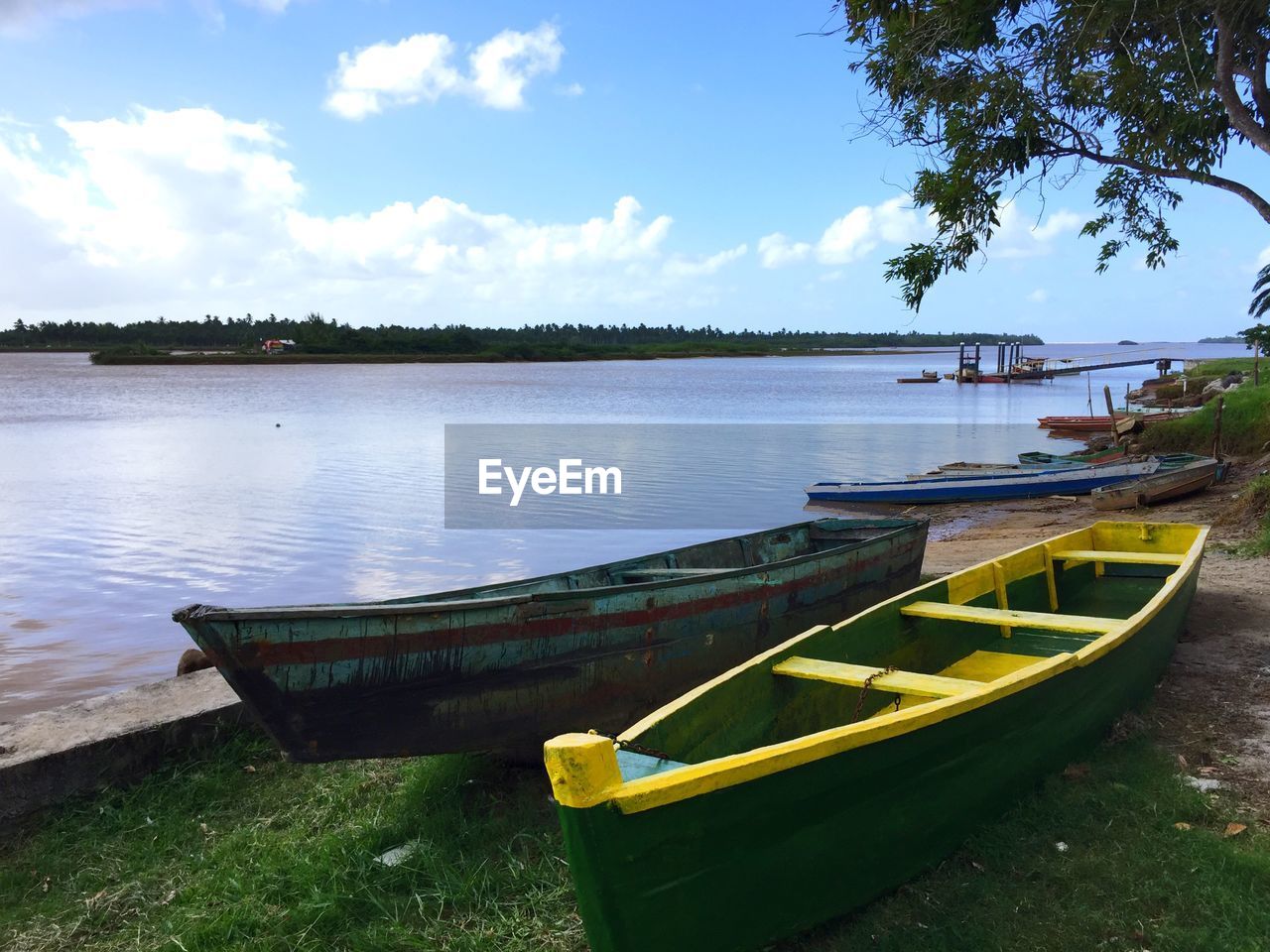 BOAT MOORED BY RIVER AGAINST SKY