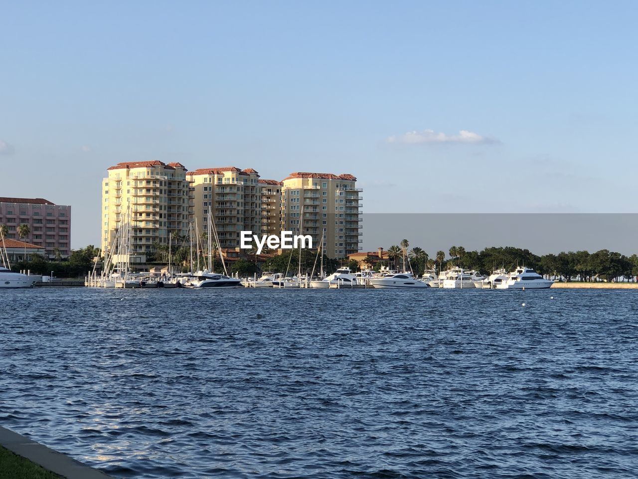 Sea by buildings against sky in city