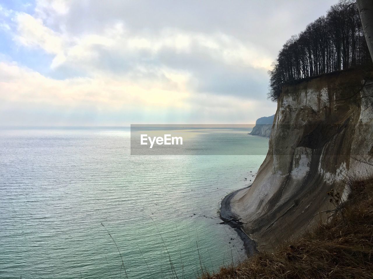 Scenic view of calm sea against cloudy sky